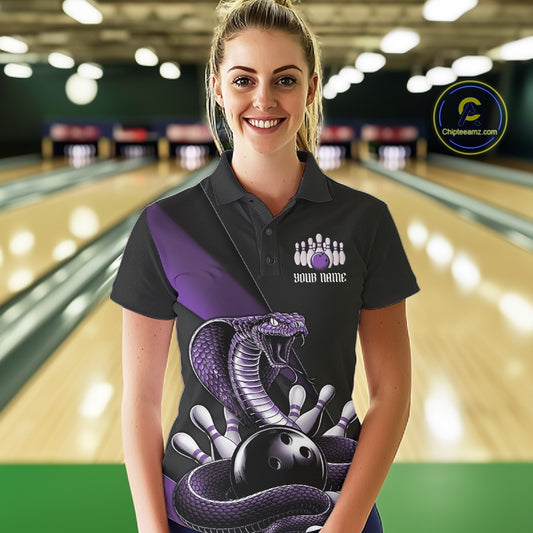 Female model wearing a black bowling polo at the bowling lane with purple cobra artwork and bowling pins.