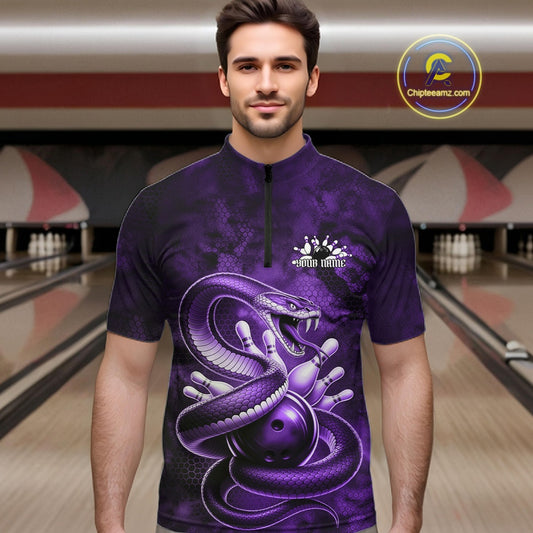 Male model wearing a bowling quarter-zip in a bowling lane with purple cobra artwork wrapped around a bowling ball and scattered pins.