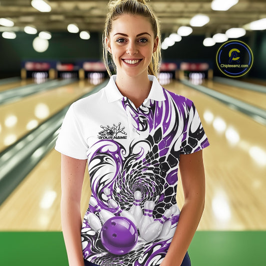 Female model in a bowling alley wearing a white bowling polo shirt with purple and black tribal accents, scale-inspired details, and a red bowling ball striking pins