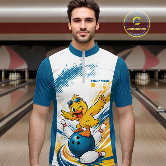 A man wearing a custom bowling-themed short-sleeve quarter-zip shirt with a cartoon duck graphic, standing in a bowling alley. The shirt features a white and blue base with yellow and blue graphic accents.