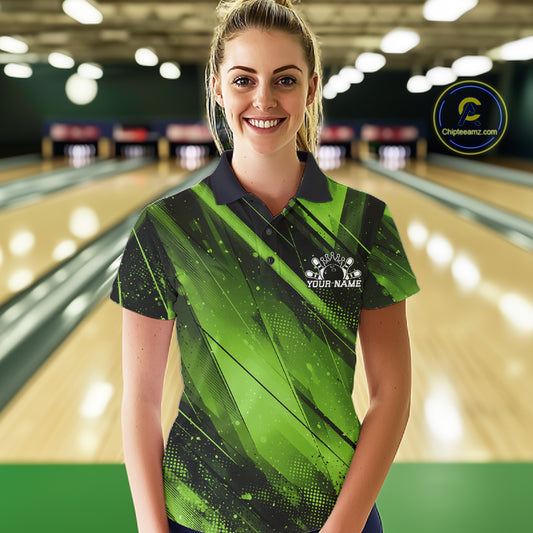 Woman wearing a green and black bowling shirt with a logo in a bowling alley.