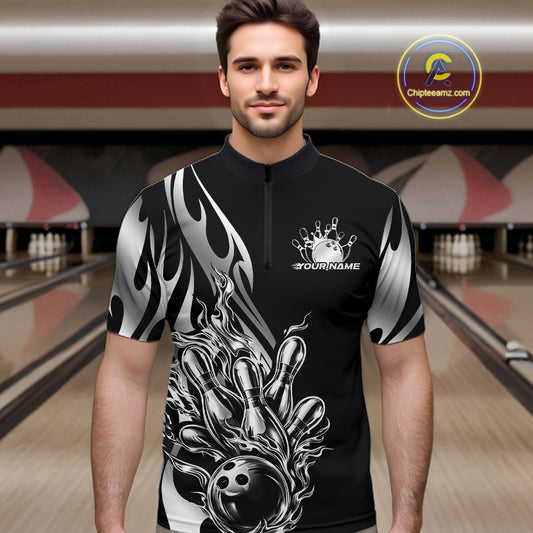 Male model front view in bowling lane wearing black quarter zip shirt with silver metal tribal flame and bowling ball knocking down pins in action.