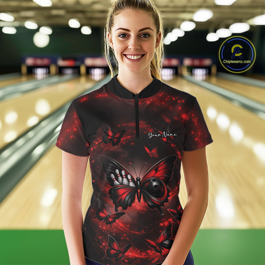 Female model shown from the front in a bowling center wearing a quarter-zip shirt with a red and black butterfly and bowling ball body artwork.