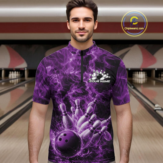 Male model at a bowling alley wearing a quarter-zip decorated with a purple bowling ball and fiery bowling strike graphics.