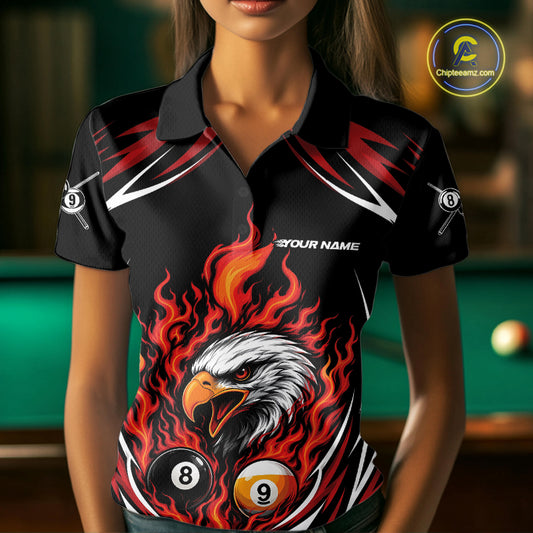 A woman wearing a black short-sleeve polo shirt with a bold graphic print featuring a white eagle head surrounded by red and orange flames, with billiard 8-ball and 9-ball