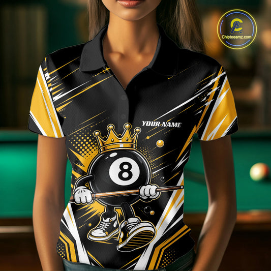 A woman wearing a custom short-sleeve polo shirt with a black, gold, and billiard 8-ball pool graphic. The shirt features a cartoon 8-ball character holding a cue stick, a gold crown, and the text 'YOUR NAME' on the chest.