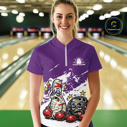 Female model in a bowling lane wearing a purple and white quarter-zip shirt, cartoon boxing bowling ball and pin illustration with playful style.