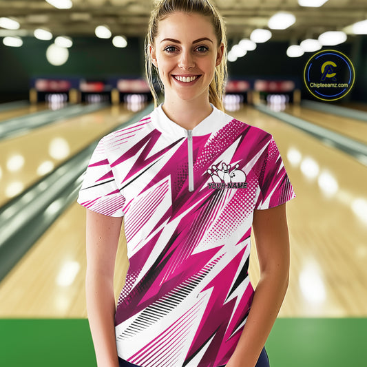 Woman wearing a pink and white bowling shirt with a pattern in a bowling alley.