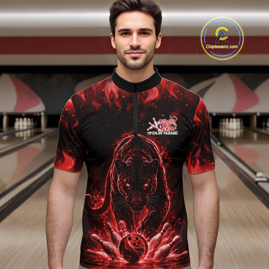Front view of a male model in a bowling lane wearing a black quarter-zip shirt with glowing red electric panther and dynamic bowling strike visuals.