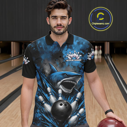 Man wearing a blue and black polo shirt with a shark design in a bowling alley.