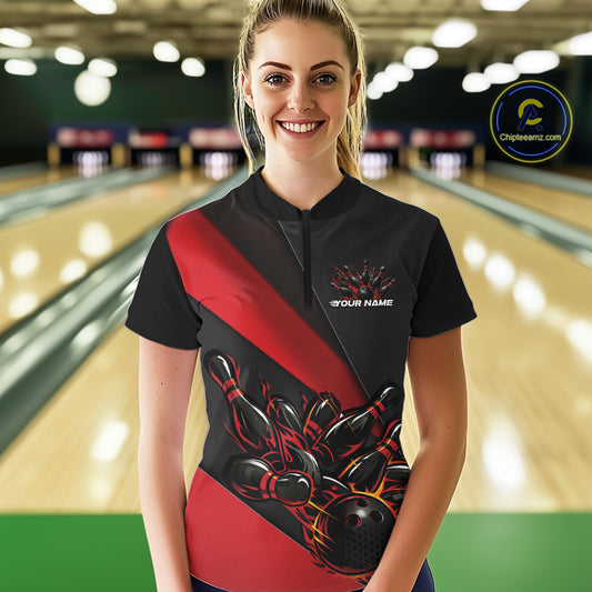 Female model front view in bowling alley wearing black and red quarter zip shirt with flame bowling action artwork