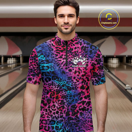 Man in a bowling alley wearing a blue, purple, pink, and black leopard-print bowling quarter zip shirt with “Your Name” and a bowling pins graphic on the chest.