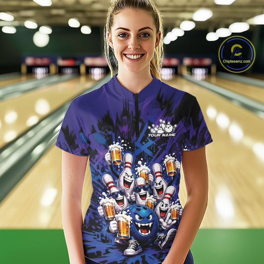 Front view of a female model at a bowling lane wearing a blue and purple bowling quarter-zip shirt featuring funny bowling pins and a bowling ball holding frothy beer mugs in a playful bowling-themed illustration.