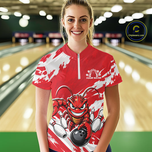 Front view of a happy female model in a bowling alley wearing a red custom quarter zip bowling shirt with an aggressive crawfish bowling design and a distressed background.