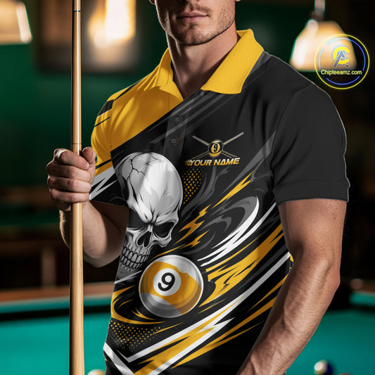 A man in a pool hall wearing a black and yellow polo shirt with a custom skull and billiard 9-ball graphic
