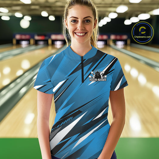 Woman wearing a blue bowling shirt with a logo and text in a bowling alley.