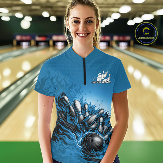 Female model in a bowling lane wearing a quarter-zip shirt, raccoon character with sunglasses and patriotic bandana leaning on a bowling ball graphic.