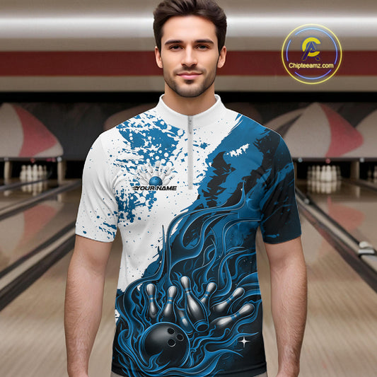 Front view of a male model in a bowling lane wearing a black quarter-zip shirt with blue and white flame bowling ball and pins graphics and energetic bowling visuals.