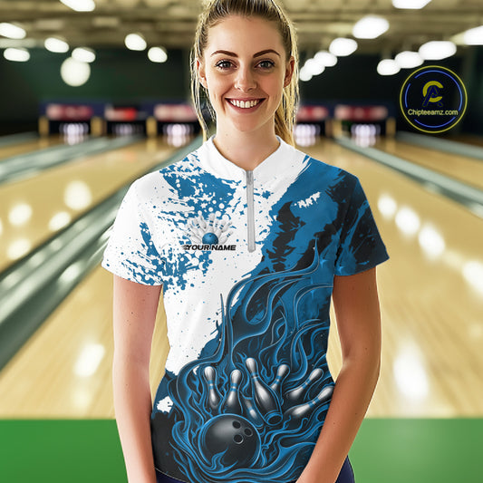 Front view of a female model in a bowling lane wearing a black quarter-zip shirt with blue and white flame bowling ball and pins illustration and dynamic bowling action visuals.