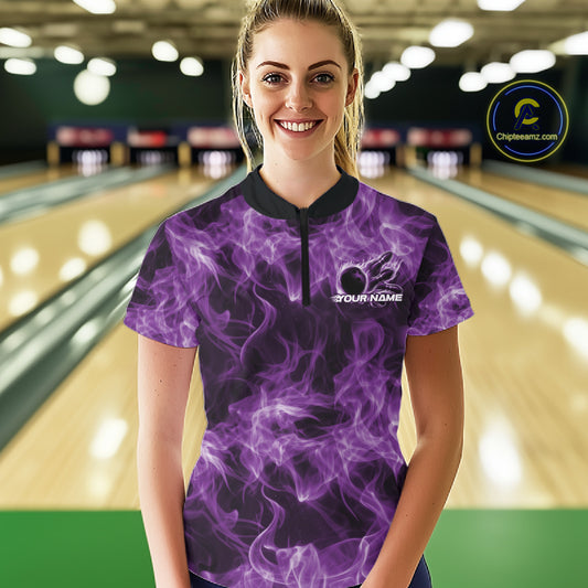Female model wearing a purple bowling quarter-zip at the bowling lane with fiery bowling ball graphics.