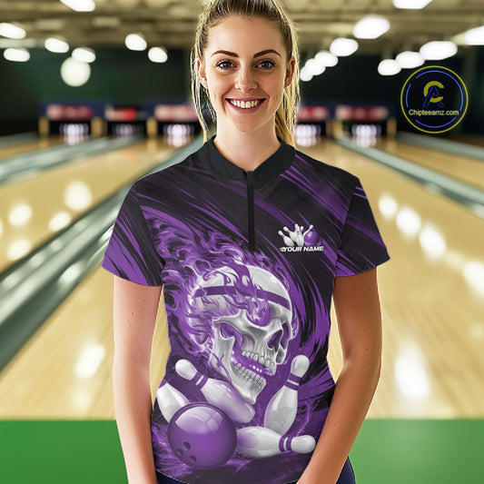 Person wearing a purple and black bowling shirt with a skull and bowling ball design in a bowling alley.