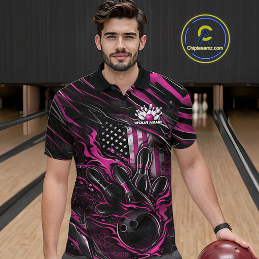 Male model at a bowling lane wearing a black and pink bowling polo shirt with a patriotic flaming bowling ball striking pins and American flag graphics.