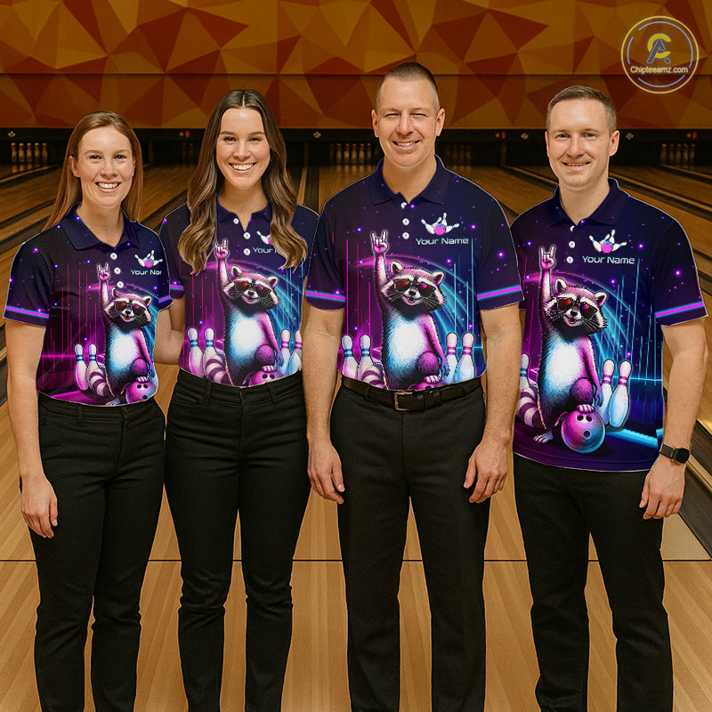 Four people standing in a bowling alley wearing matching dark purple bowling shirts with a colorful raccoon and bowling pins graphic, paired with black pants.