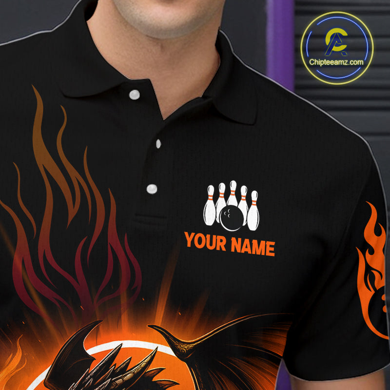 A close-up of a black short-sleeve polo shirt worn by a model. The shirt features a graphic design with orange and red flames, a bowling pin and ball motif, and the text 'YOUR NAME' in orange on the left chest.