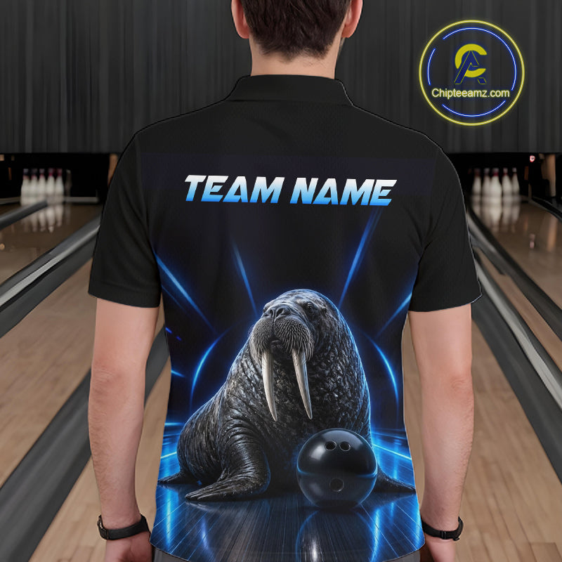 Person wearing a black t-shirt with a walrus graphic and 'TEAM NAME' text in a bowling alley.