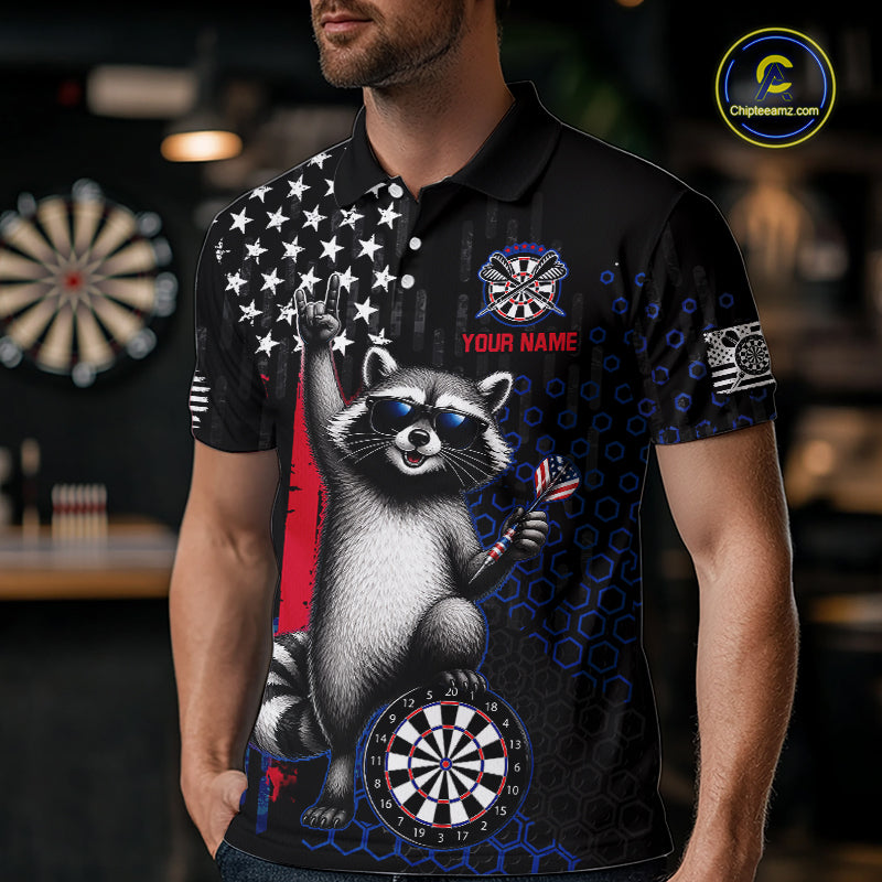 Man wearing a custom patriotic dart polo shirt featuring an American flag raccoon holding darts beside a dartboard in a professional dart room.