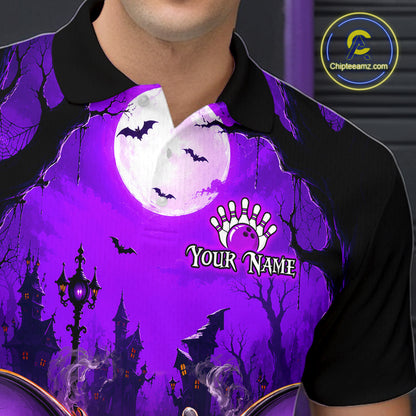 A close-up of a person wearing a black short-sleeve polo shirt with a vivid purple Halloween-themed graphic print featuring a full moon, bats, haunted houses, bare trees, and a customizable name graphic.