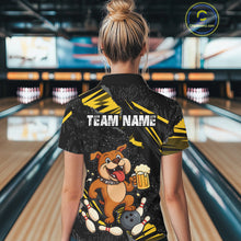 Load image into Gallery viewer, A woman wearing custom black yellow bulldog bowling polo shirt back view featuring a bowling ball, beer mug and yellow paint splash pattern, displaying Team Name, at the bowling alley