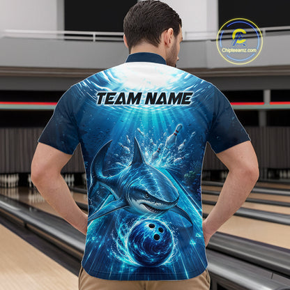 Man wearing a blue bowling shirt with shark design and 'TEAM NAME' text on the back, in a bowling alley.
