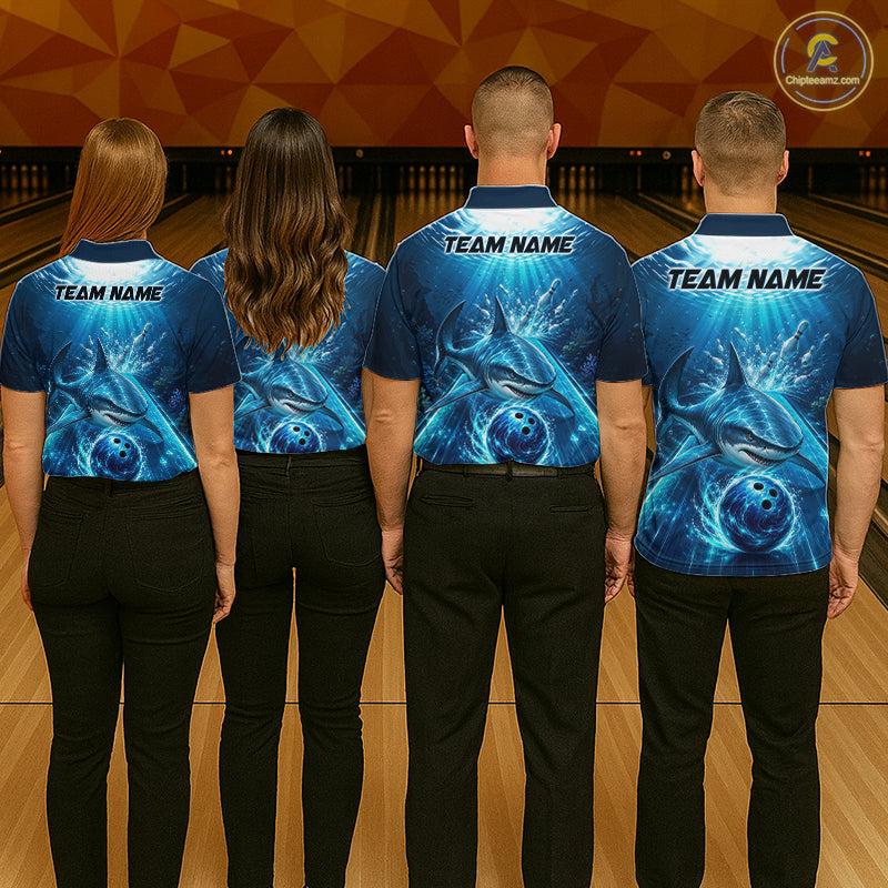 Four people wearing blue bowling shirts with a team name on a bowling alley.