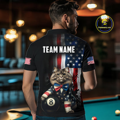 A back view of a custom black billiards polo shirt worn by a male model turned away from the camera in front of a pool table. The shirt features a large distressed US flag pattern on the back, with a large white 'TEAM NAME' text placeholder. A cat and 8-ball motif is at the bottom of the flag design. The background is a billiards room with a table and hanging lights.