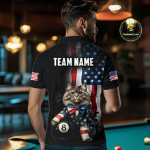 Load image into Gallery viewer, A back view of a custom black billiards polo shirt worn by a male model turned away from the camera in front of a pool table. The shirt features a large distressed US flag pattern on the back, with a large white 'TEAM NAME' text placeholder. A cat and 8-ball motif is at the bottom of the flag design. The background is a billiards room with a table and hanging lights.