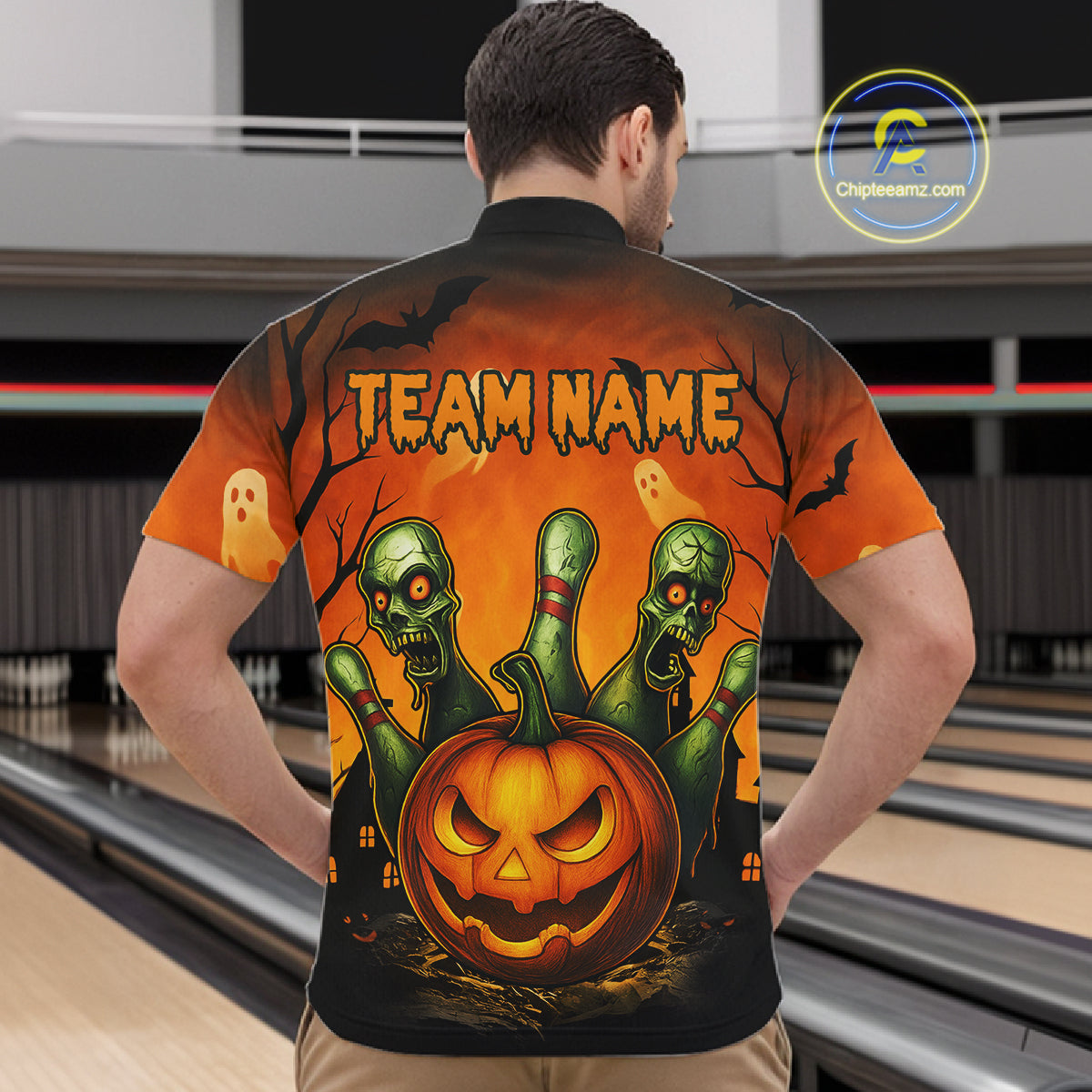 Person wearing a Halloween-themed shirt with pumpkins and zombies design in an indoor setting.