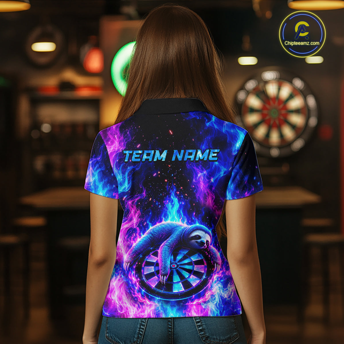 Back view of a woman wearing a custom galaxy dart polo with personalized team name and a neon sloth holding a dartboard with glowing blue and purple cosmic artwork in a professional dart room.