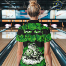 Load image into Gallery viewer, A woman viewed from behind wearing a green and black short-sleeve bowling shirt with a frog and bowling ball graphic on the back, standing in a bowling alley. The shirt has 'Team Name' printed across the upper back.