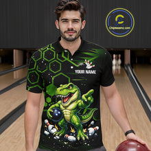 Load image into Gallery viewer, A man wearing a black short-sleeve bowling polo shirt with a green cartoon dinosaur graphic, bowling pins, and the text 'YOUR NAME' on the chest. The background shows bowling lanes, and a circular 'Chipleeamz.