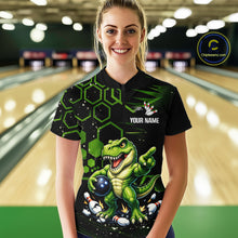 Load image into Gallery viewer, A woman stands in a bowling alley wearing a black short-sleeve bowling shirt with a green cartoon dinosaur graphic and the text 'YOUR NAME'. The background shows blurred bowling lanes, and a circular 'Championship.