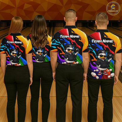 Four people standing from the back in a bowling alley, wearing matching bowling shirts with a colorful duck graphic and 'TEAM NAME' text on the back.