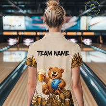 Load image into Gallery viewer, Person wearing a shirt with a bear holding a bowling ball design in a bowling alley.
