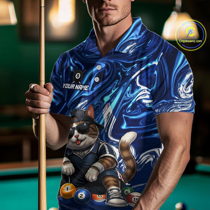 Man wearing a blue shirt with a cat design holding a pool cue on a pool table.