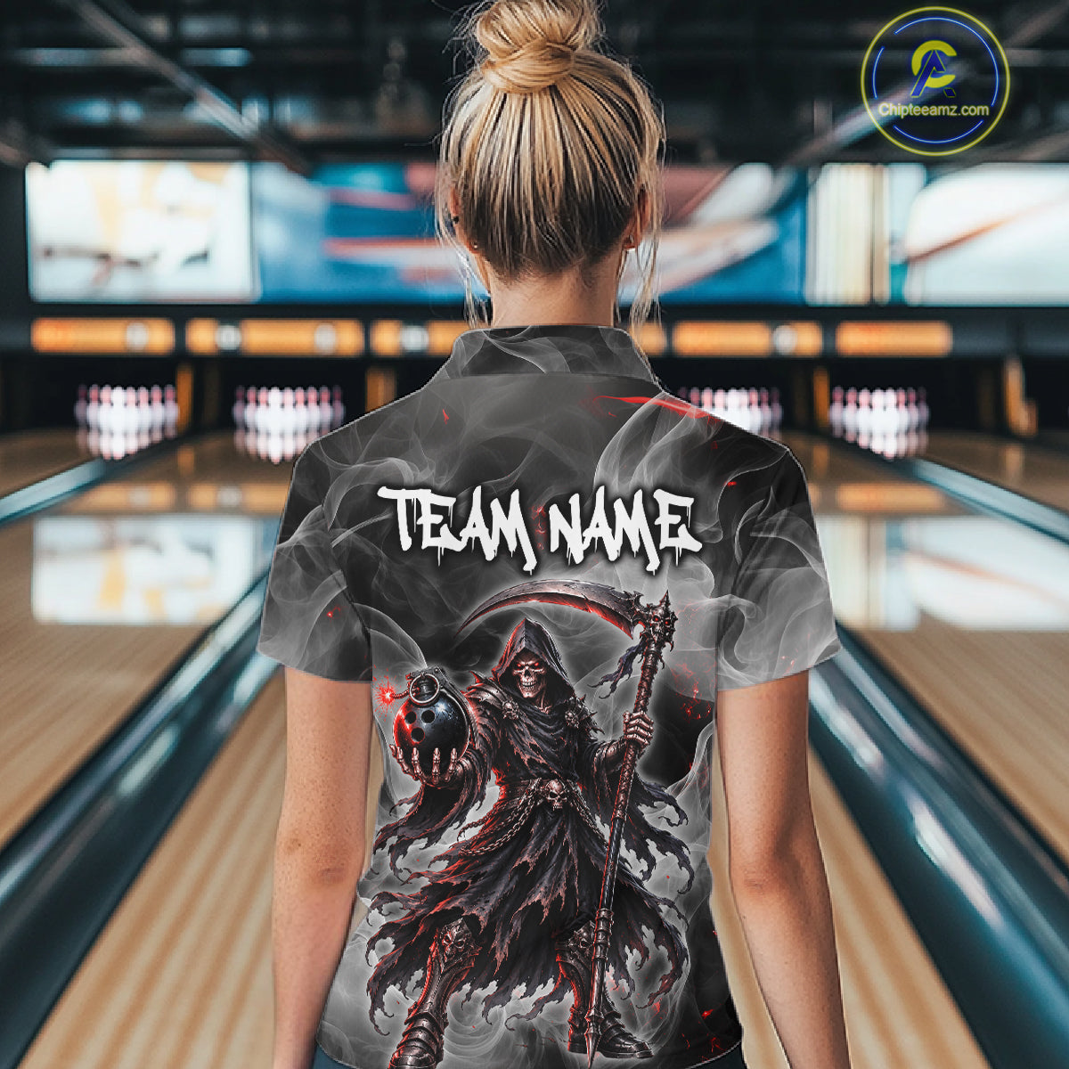 A woman viewed from behind wearing a custom bowling shirt with a dark grim reaper graphic and the text 'TEAM NAME' on the back, standing in a bowling alley.