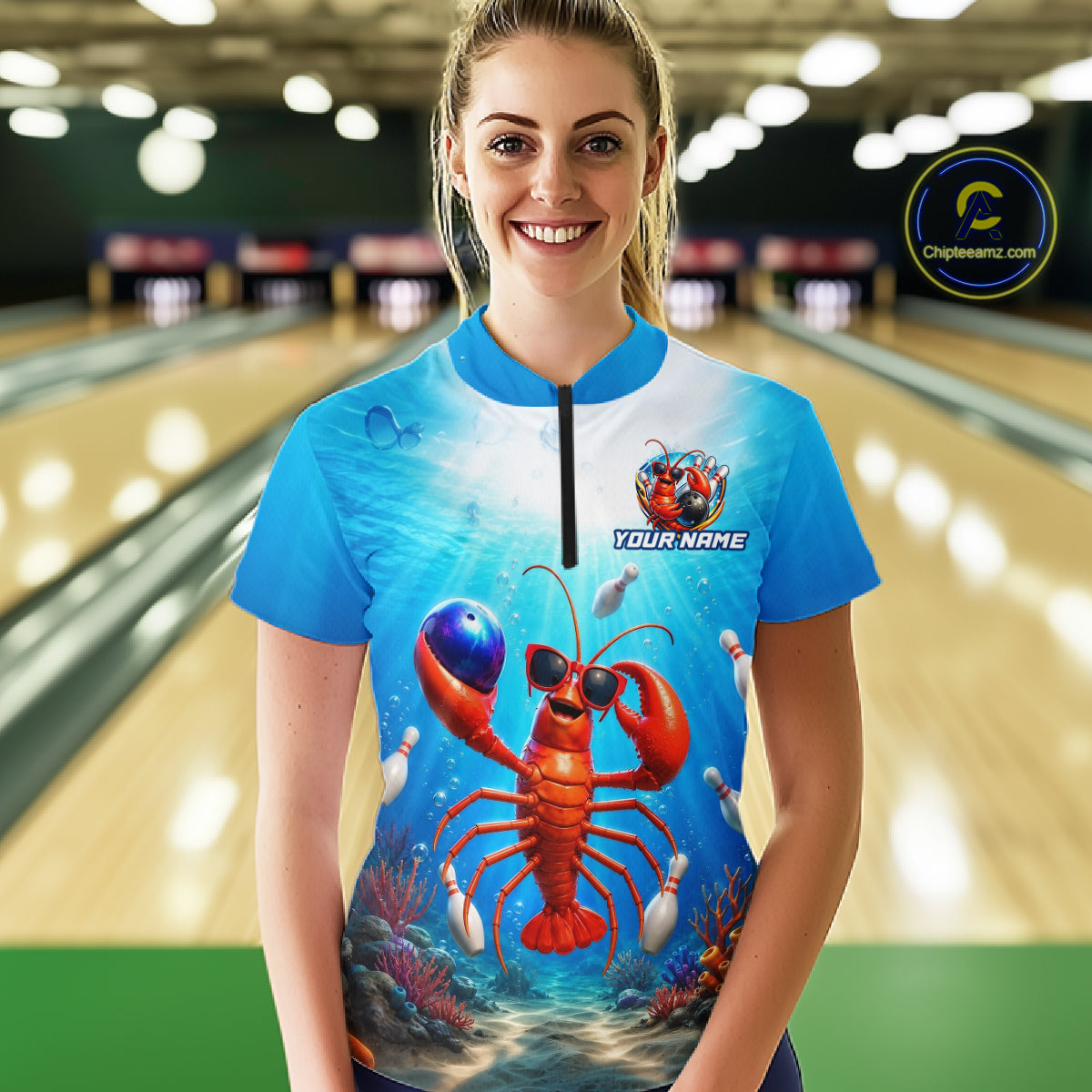 Woman wearing a blue bowling shirt with a lobster design in a bowling alley.