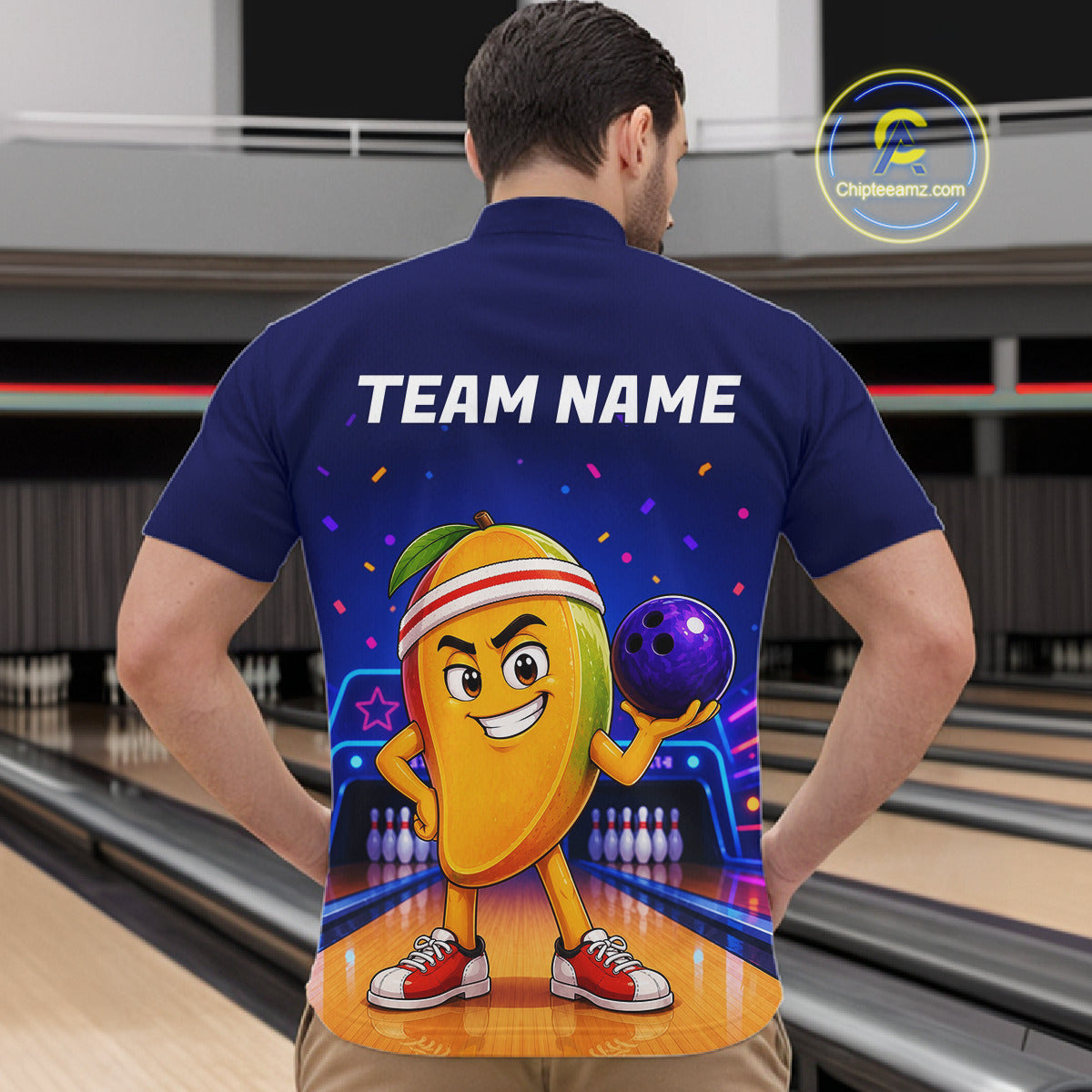 Person wearing a blue shirt with a cartoon character holding a bowling ball on a bowling alley.