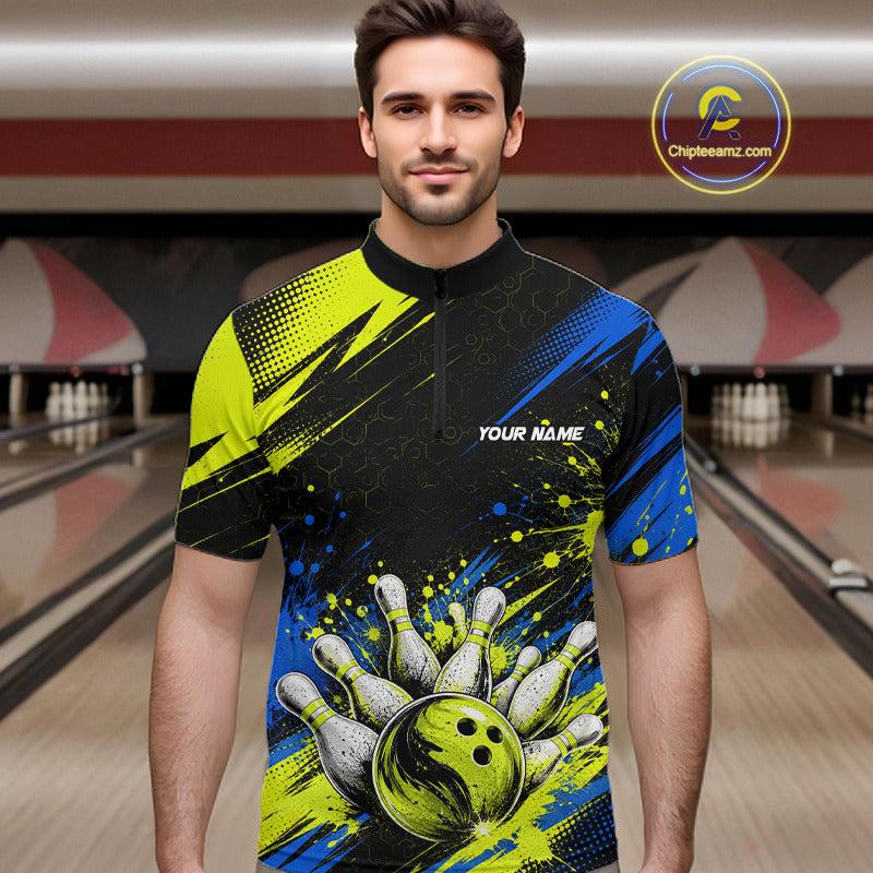 A man wearing a short-sleeve bowling-themed quarter-zip shirt with a black, blue, and neon yellow graphic design featuring bowling pins, a bowling ball, and the text 'YOUR NAME'. The background shows blurred bowling lanes