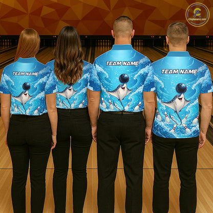 Four people standing with their backs to the camera in a bowling alley, wearing matching blue bowling shirts with a dolphin graphic and black pants. The shirts have 'TEAM NAME' printed on the back.