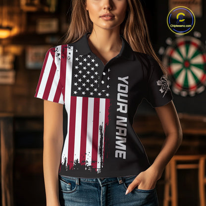 A woman wearing a custom brown dart polo shirt featuring a distressed American flag graphic in a professional dart room.